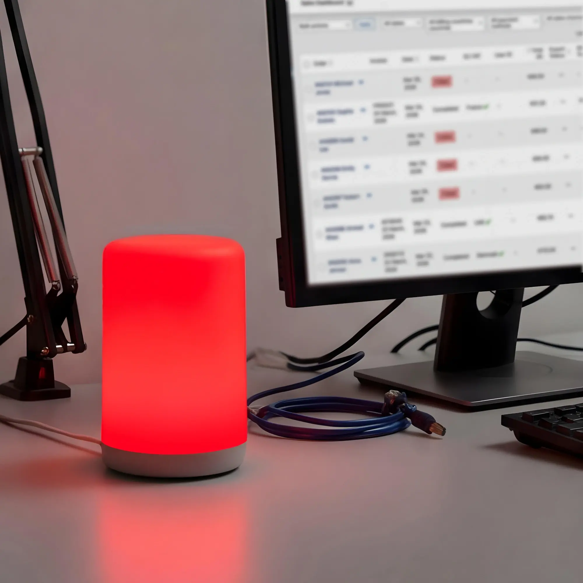 Luxafor Signal glowing red on a packing desk, visible from across the room